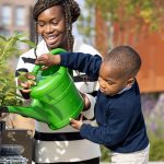 Residents watering plants in community garden